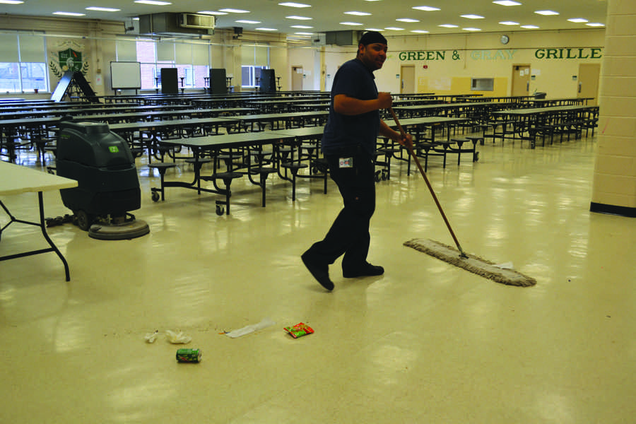 Janitorial worker Darryl Ayers cleans up the mess left in the cafeteria.