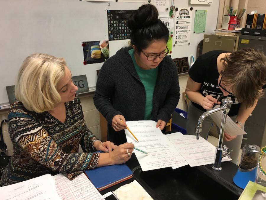 Ms. Davis explains a worksheet to students Annie Pham (10) and Sandy Chasse (11)
