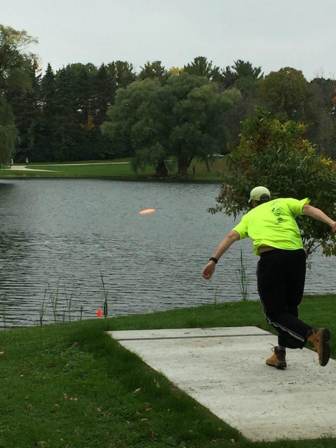 Daniel Zich launches a disc across the lake during his Disc Golf match