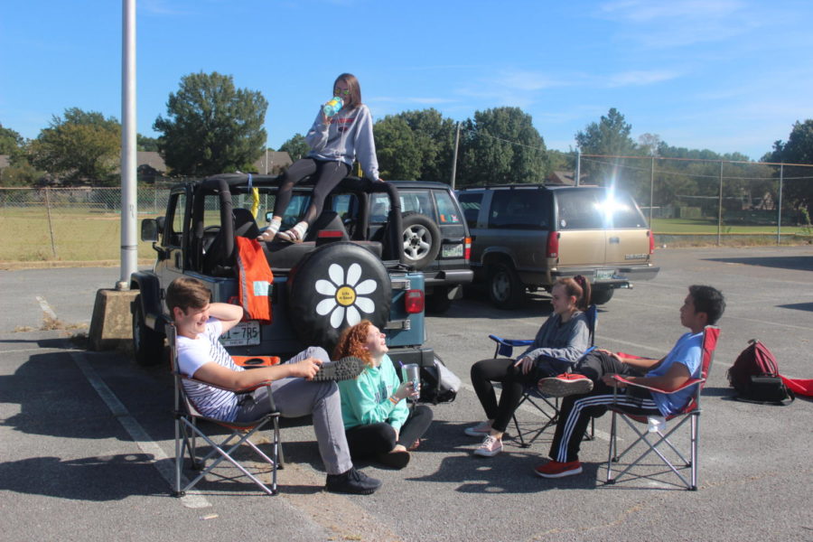 Members Lucas Schupp (11), Emily Cooper (11), Padethkane Rasasack (11) and Andrea Brimhall (11) socialize after school in the senior gym parking lot with LCS president Chloe Carter (11). 