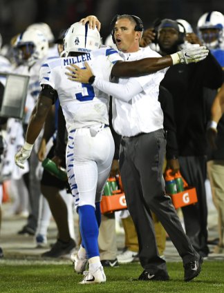 Head Coach Mike Norvell embraces star receiver Anthony Miller after he tallies four touchdowns in a win against Connecticut 
