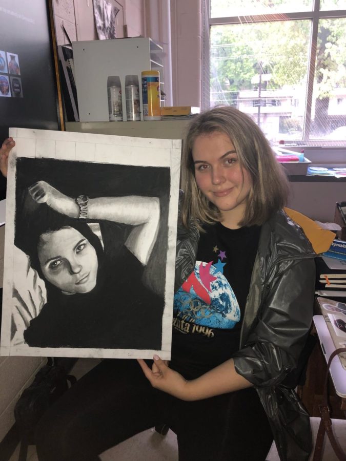 Lizzie Boyer poses with her art piece. 