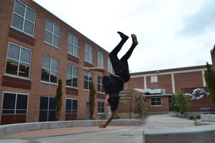 Hayden Gowen (10) completes a front flip in the courtyard at White Station. Gowen began doing parkour in the seventh grade and plans to continue in the future.  