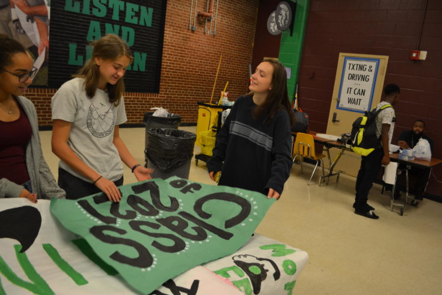 Students (from left) Autumn Jones (10), Amalie Vacanti (10) and Rylie Duke (10) review signs for the Class of 2021.