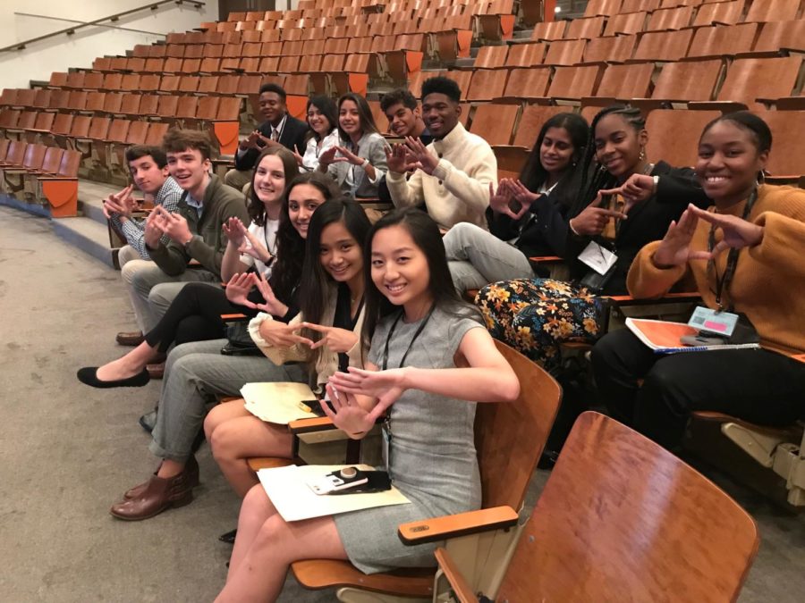 The current and future members of the DECA Executive Board are seated, waiting for the first presentation of the conference to begin. They are holding up their “DECA Diamonds” in support of their chapter. 
