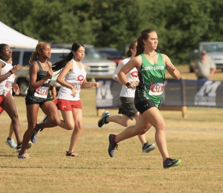 After the official fires the pistol, Zoe Wolfe (11) gains a lead over competitors from Germantown and Whitehaven at the cross country meet at Shelby Farms. Despite the heat,  she strives to run her best and make the most of the experience. 