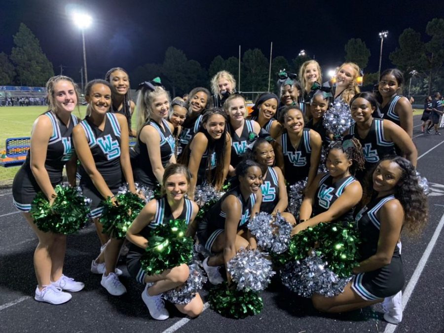 The Spartan Cheer Team poses for a picture after hyping up the crowd at a football game. The team had a successful season, placing second at the MidSouth Regional Cheer Competition. 