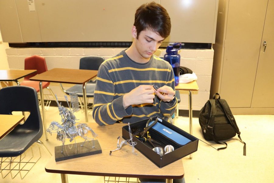 Ben Erickson(12) takes out his equipment in class to work on his latest sculpture. His wire art creations have become recognized by Spartans for their incredible detail and precision.