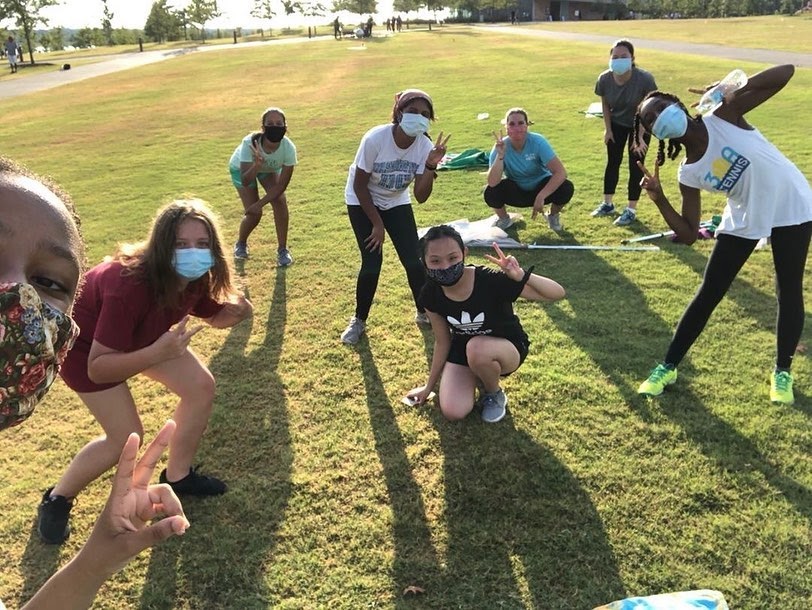 After practice, Rebekah Butler (10, farthest left) takes a quick team selfie. The team is still going strong, even with masks and other safety procedures prohibiting some aspects of color guard.