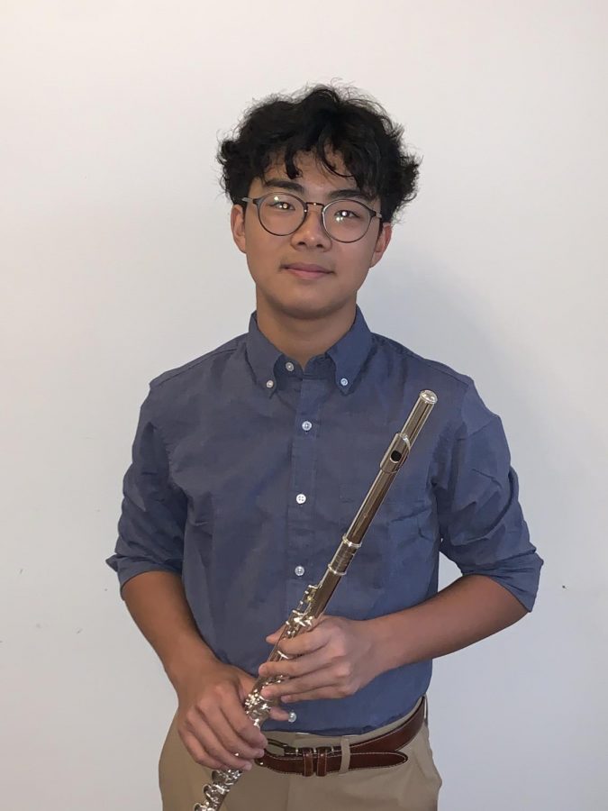 Matthew Kim poses for a headshot with his flute. At the end of last year, Kim received a merit award after seven years of experience.