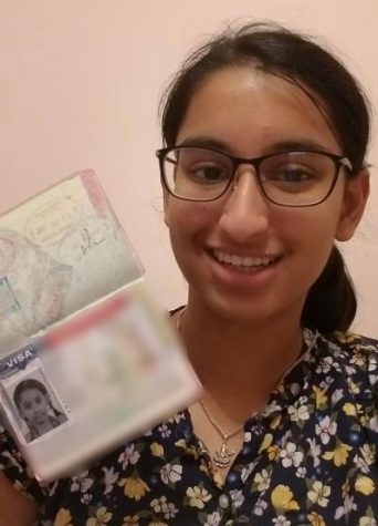Aditi Mishra (11) poses with her immigrant visa. Mishra and her family immigrated to the U.S. from Nepal in November 2011.  