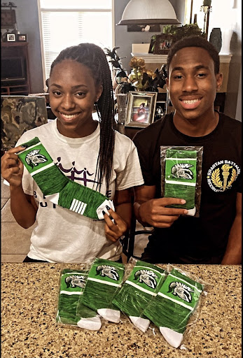 Hannah Heaston (11) (left) and Dylan Heaston (11) pose for a picture as they show off some of their products. These Spartan socks are their newest release among the varieties of socks they sell.