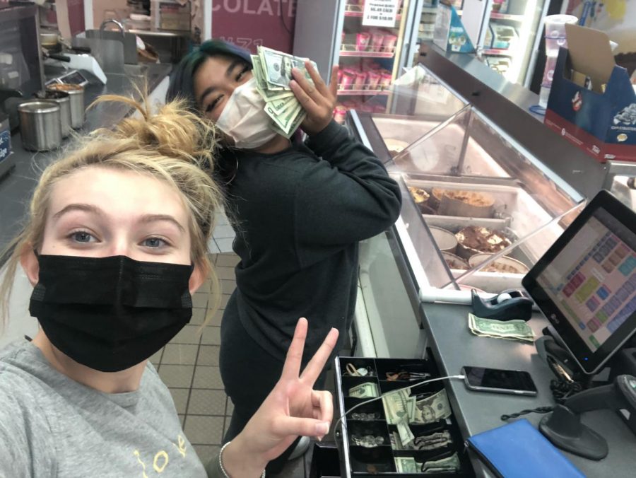 Grace Goodson (left front) and her co-worker at Baskin Robbins manage the cash register and display the day’s bounty. Freezers full of ice cream await their scooping and readiness to serve customers. 