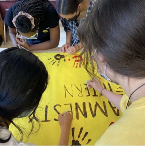 Members of the Amnesty Club place their painted handprints on a banner in solidarity of the gun violence crisis. The group received recognition from Amnesty International USA for their efforts in breaking the cycle of gun violence.
