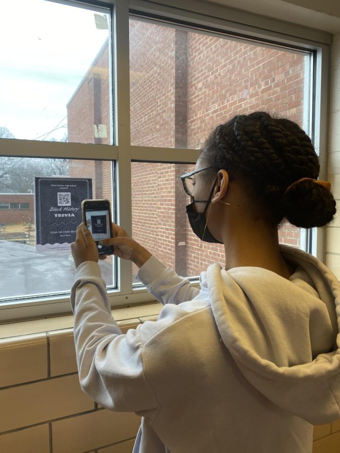 Rebekah Butler (11) holds up her phone to scan a QR code to a black history trivia contest. Thanks to the efforts of Mary E. Pittman (12), events such as this have been planned throughout February to celebrate Black History Month. 
