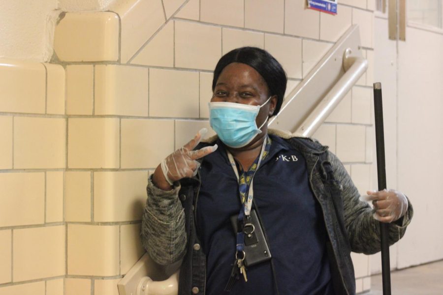 With a broomstick in one hand, Shameka Wilson poses along the staircase of the East Annex leading towards the cafeteria. She usually checks in with students eating lunch and encourages them to clean up after themselves when necessary. 