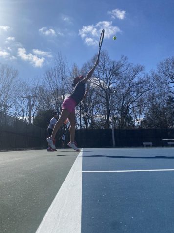 Sofia Gosain (11) serves the ball as she warms up for practice. As the team prepares for matches, players gather twice a week at Wolbrecht Tennis Center. 