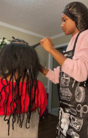 Kimora McGee (12) craftily styles her client’s hair into soft locs. Her business, kashdoesmyhair, has steadily grown in popularity over the past year and a half.