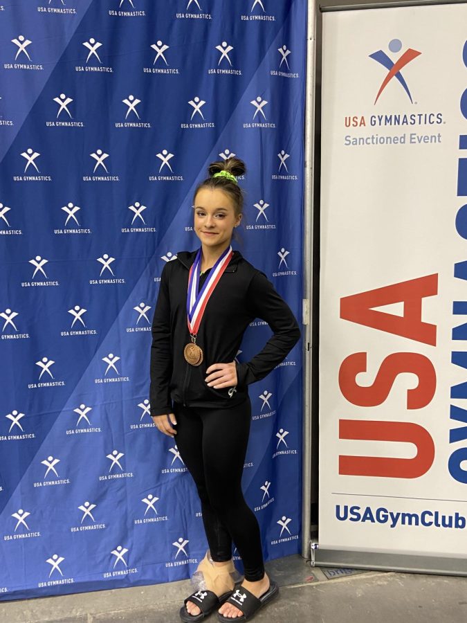 A nationally competing gymnast and verbally committed to Auburn, Olivia Ahern (11) poses with her multiple medals. Training since she was two-years-old, her experience with gymnastics has been a journey, but a rewarding one. 