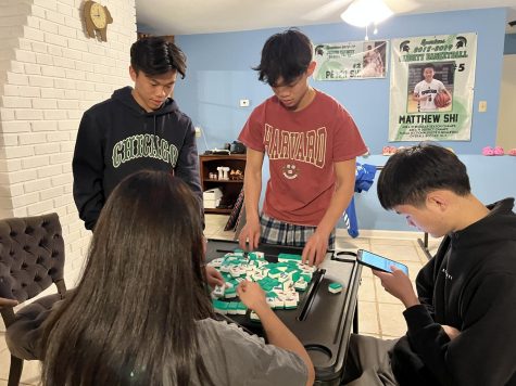 (Clockwise from top) Matthew Shi (12), Peter Shi (11), Perry Shu (12) and Eilene Liu (12) research how to play mahjong. The game, which originated in China in the 19th century, was one of the potential activities for the night.