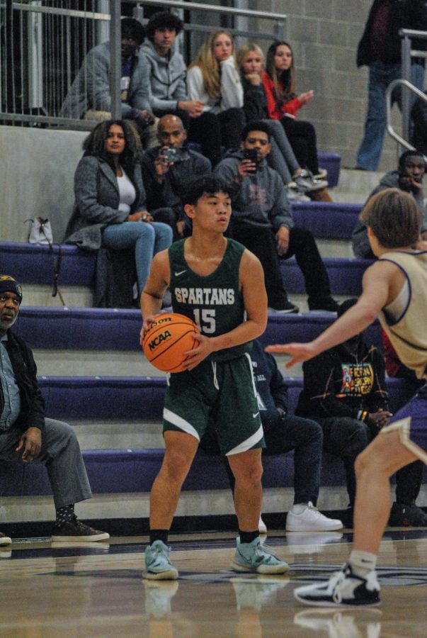 Peter Shi (11) looks for an open man to pass the ball to during the first game of the season at Christian Brothers. The final score was 56 vs. 47 and the Spartans were defeated by the Purple Wave. 