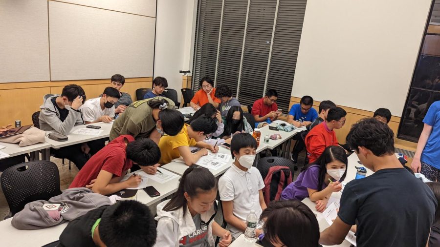 The White Station Math Team (middle row) huddles together to solve logic puzzles at an event at the Massachusetts Institute of Technology. All teams competed to solve the puzzles for small prizes. 

