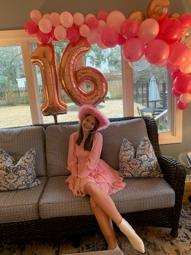 Meg Rainey (11) poses in front of a balloon arch she created for a 16th birthday party. Crafting balloon arches is something Rainey has enjoyed  since middle school.
