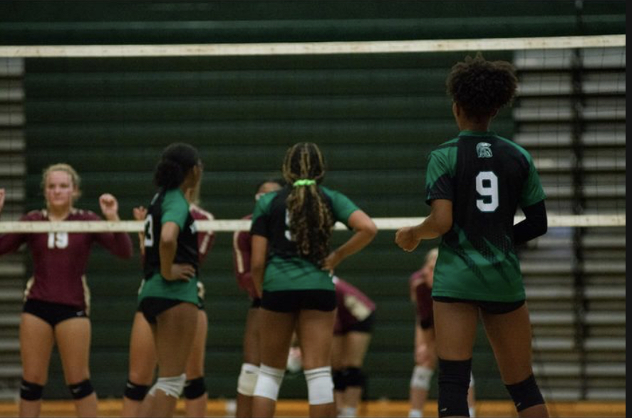 Alaya Rhodes (12), #9, faces the net from the back row while her team prepares to serve. Her team fought hard during this game. 