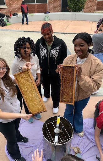 Members of the Bee Club hold honey frames that they have just extracted. Honey extraction is one aspect of beekeeping that members get to participate in on campus.