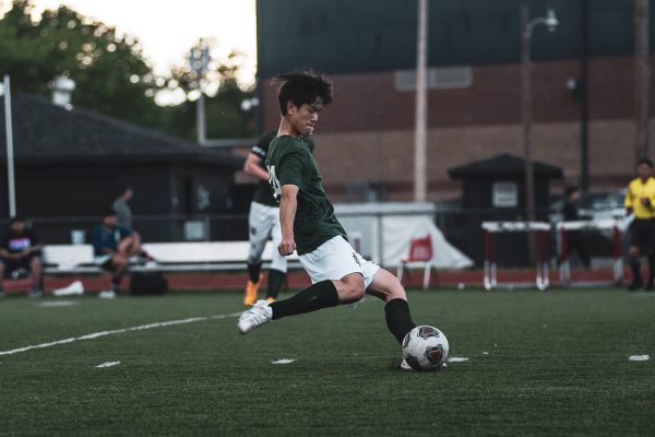 Tyler Yang (12) clears the ball in a game against Germantown High School. For many, the local high school team is the most accessible way one can play soccer and train to get better.
