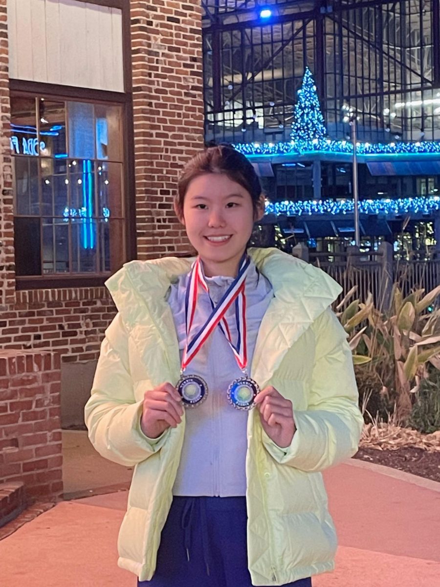 Emma Wang (9) holds up her medals after the Louisville, KY Springhurst New Year’s Tennis Competition. She placed third after four hours on the court during the quarterfinals.