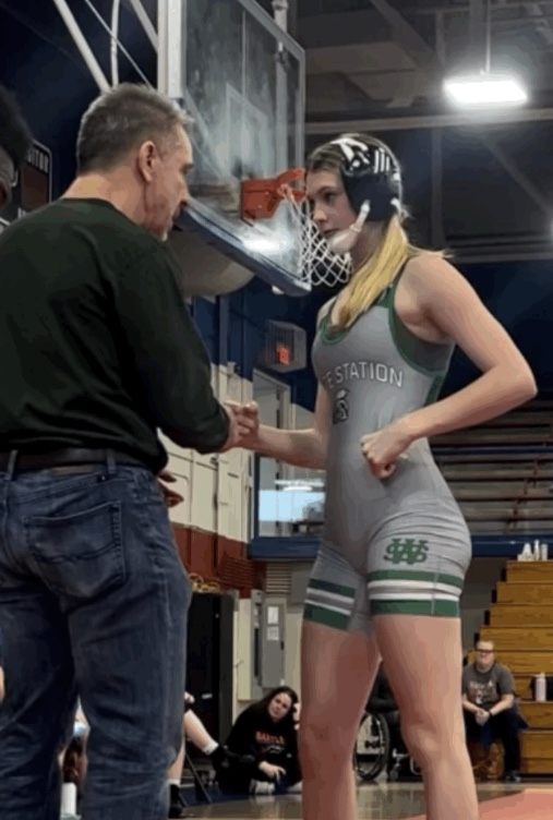  Jim Kurts, wrestling coach, and Kayleigh Angona (10) go over tactics one last time before she steps onto the mat for her last round on December 22, 2023. On this day, she won against four wrestlers from Arlington, Bartlett, Collierville and Millington that day. 