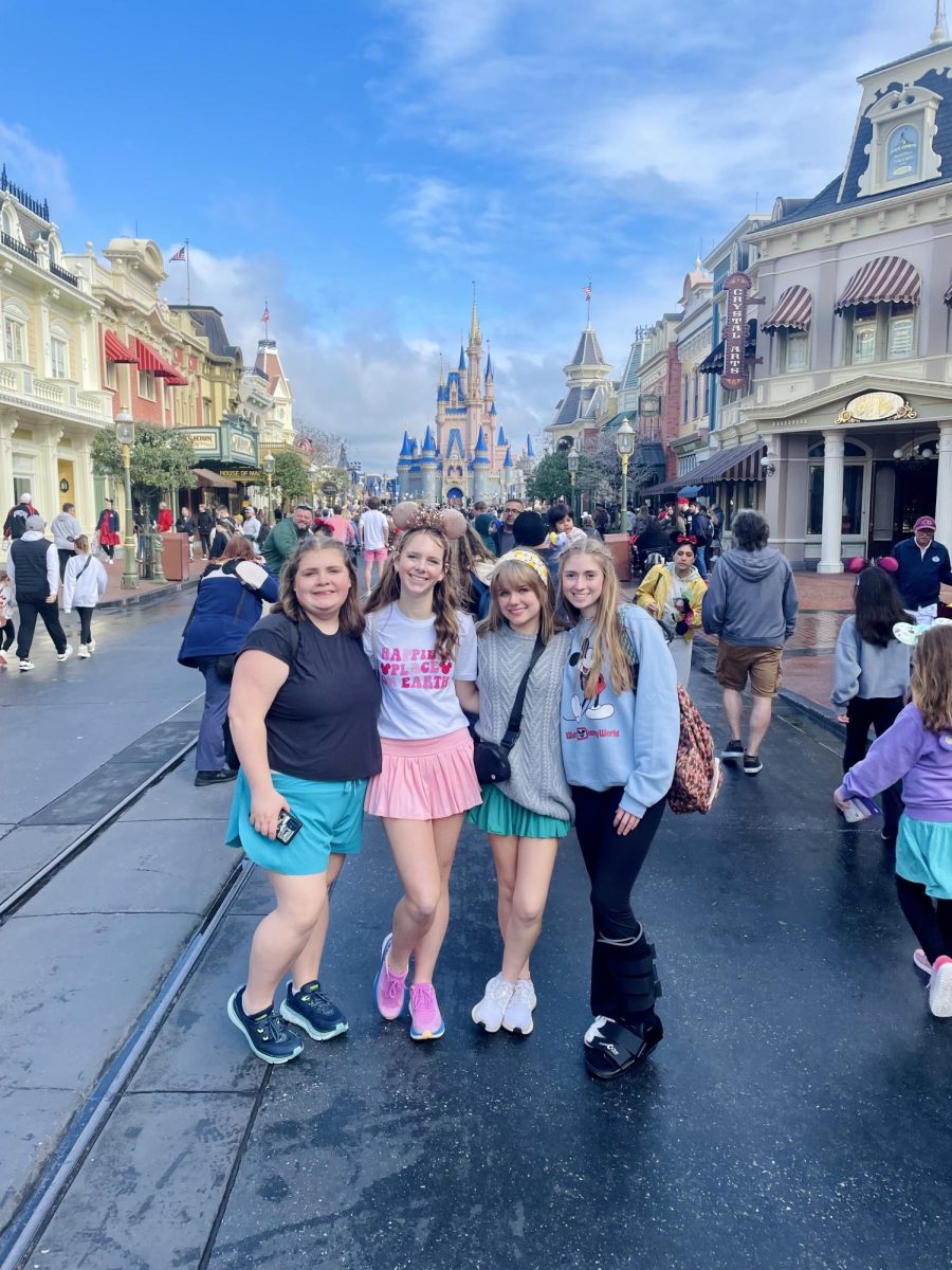A group of choir students pose in front of Cinderella Castle on Main Street in Magic Kingdom. The group was recreating a photo taken during a trip to Disney World in 2020 when they were in 7th grade.