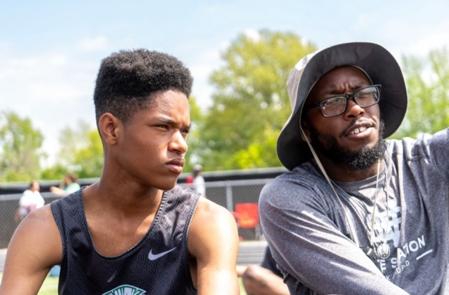 Kameron Kearney (11) speaks with Coach Kevaughn Griffith at the Houston track meet. This is his third year running track and cross country.
