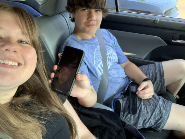 Abby Mitchell (10) and Carter Mitchell (9) talk in the car on the way to a camp. Both attend White Station High School and are 15 months apart in age.