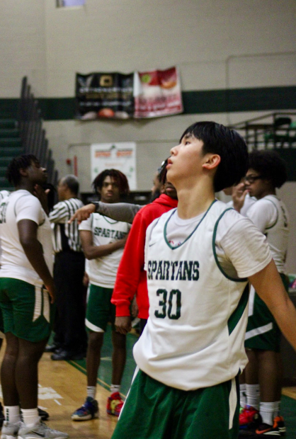 James Jin (10) looks at the rim after shooting a three pointer. In addition to playing basketball, he takes six AP classes and leads an engineering club.