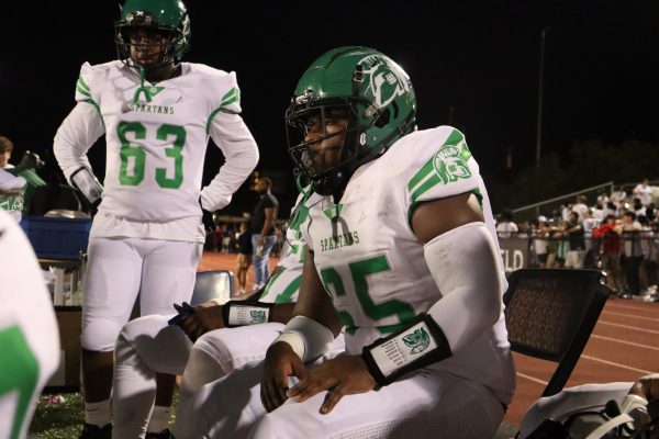 Chancellor Gray (12), number 65, waits on the sidelines for the second half of the game to begin. Although he does not want to play football in college, he has risen to a position of responsibility in the team because of his leadership and skill.