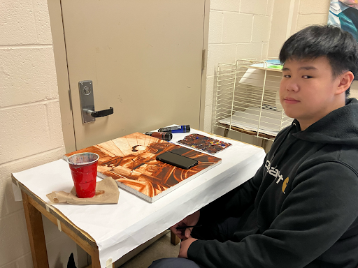 Long Do (11) works on his painting in the AP 2D Art and Design classroom. He creates a detailed underpainting for each of his works to get the value balance just right.