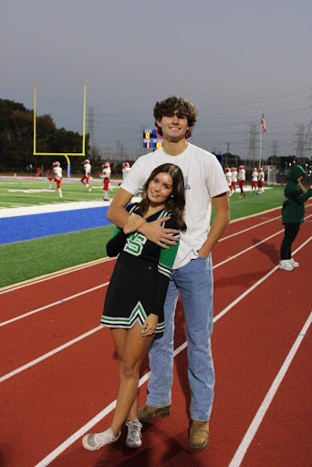 Alexa Nalos (12) and her boyfriend Tanner Phillips pose for a picture on the sidelines of a White Station High School football game. Nalos and Phillips met during quarantine when they would play outside with their siblings, eventually hanging out together more often.