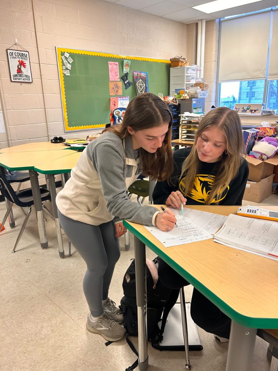 Kailyn Card (11), pictured on the left, often works with students in Elizabeth Kirby’s Pre-AP Algebra II class as a teacher assistant. Card helps answer students’ questions, grade papers and complete any other tasks Kirby assigns.