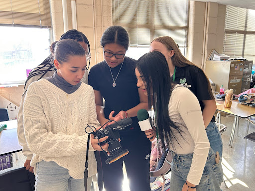 Members of the Communications team review photos on one of their cameras. The Communications team has previously covered school events and programs like Black History Month and Homecoming.