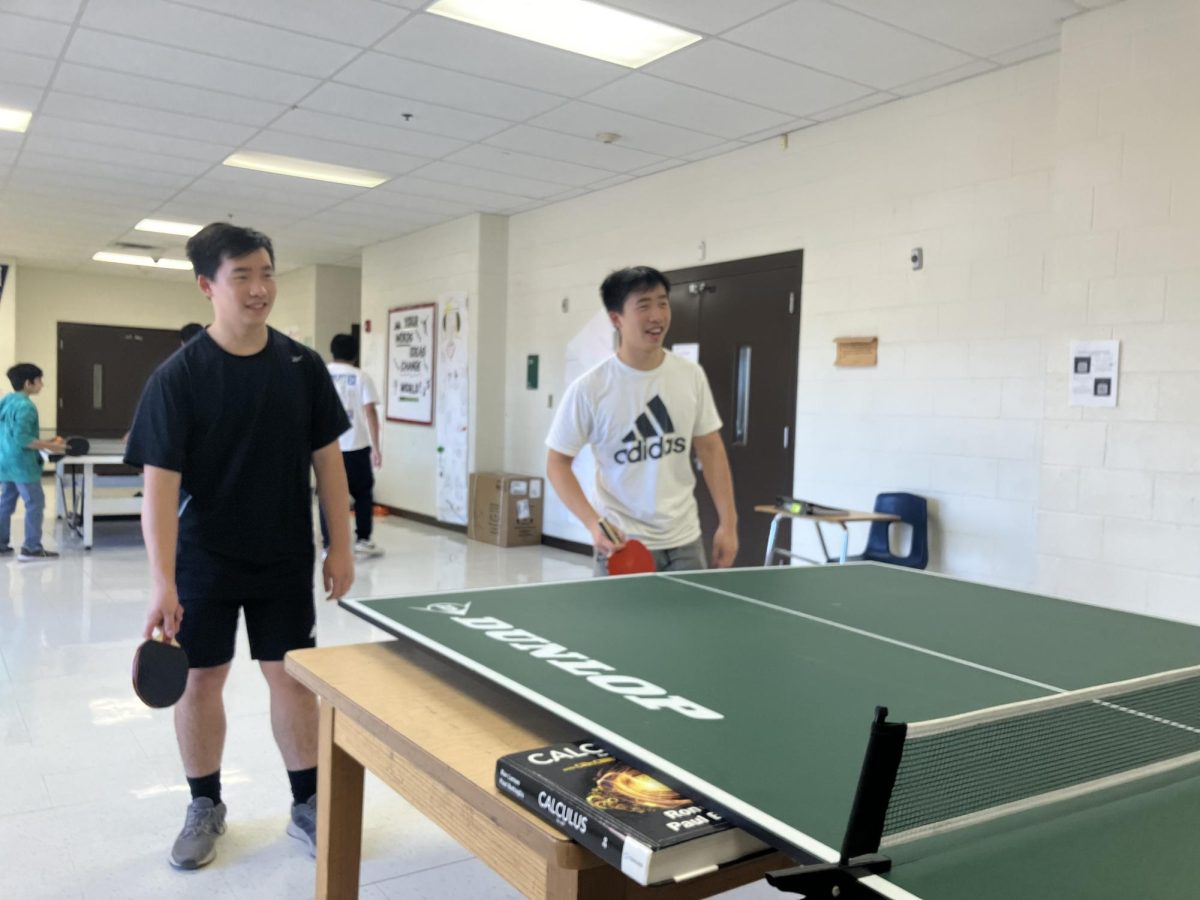 Evan (left) and Alex (right) Shi (10) play doubles ping pong on Thursday after school. The playing surface is folded onto a wooden table, often having to be balanced with textbooks below.