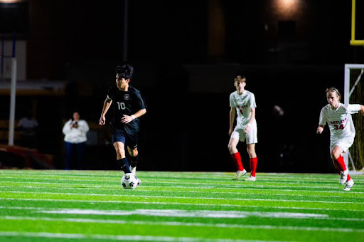 Aldair Manuel (12) dribbles head-on against Bartlett High School. Manuel was a captain of the team during his junior year. 