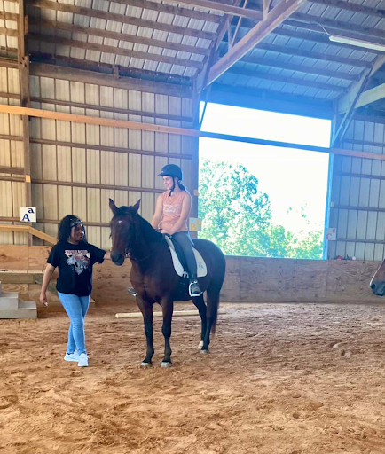 Fiorella Villeana (12) walks alongside patients as a part of the equine therapy program. Southern Reins has made sure each volunteer receives proper training before their shifts. 
