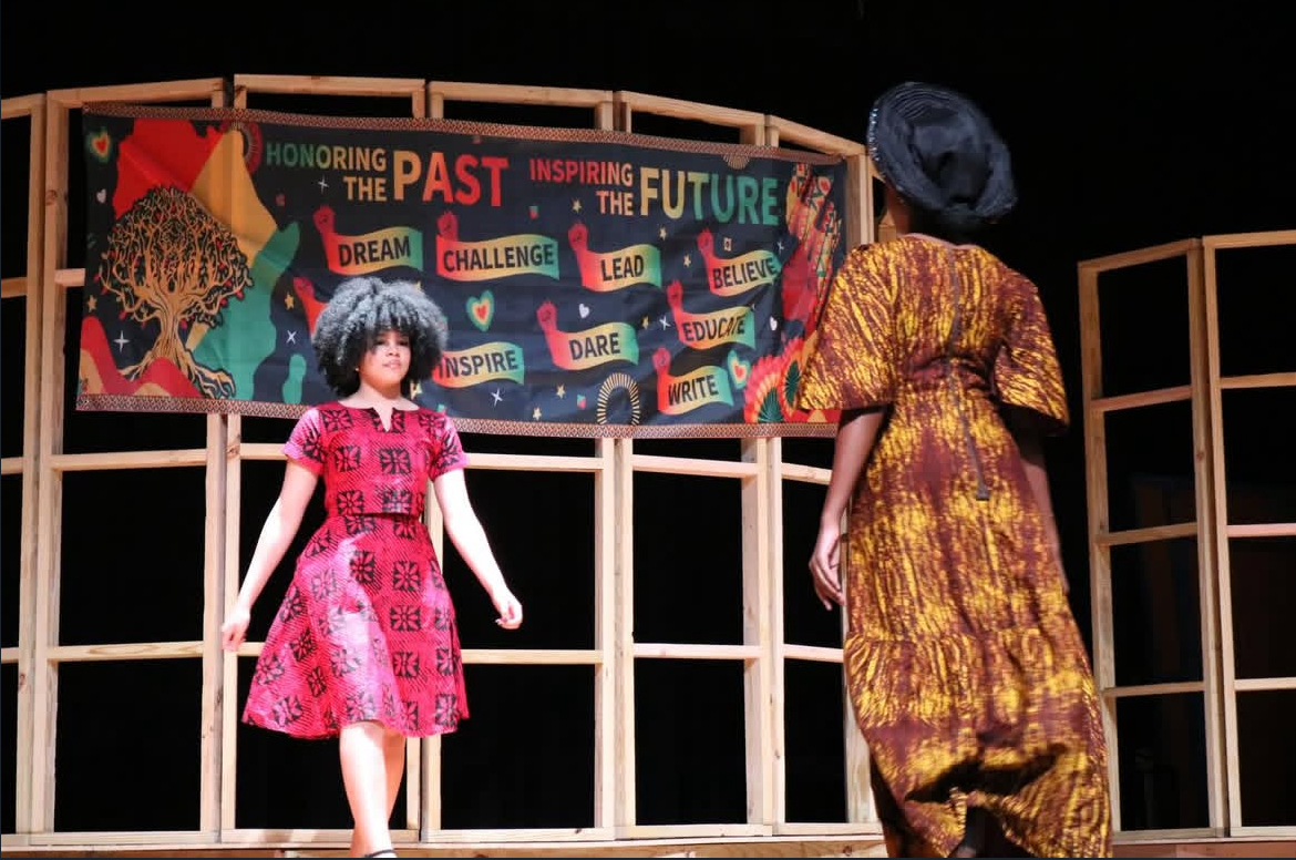 Kendall Bell (11) walks down the runway in the fashion show portion of the program. She wore a Nigerian traditional dress.