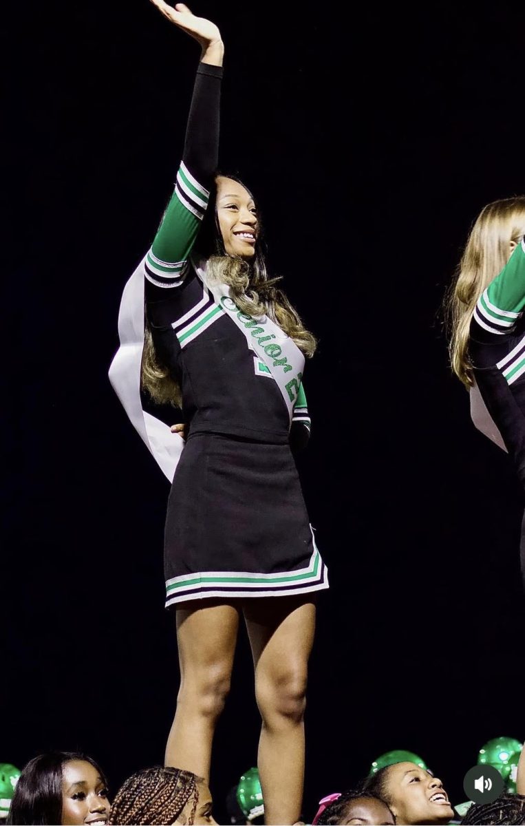 Kaitlyn Threatt (12) performs a stunt on her football cheerleading senior night. After not making the team freshman year, Threatt decided to try out her senior year at the last minute.