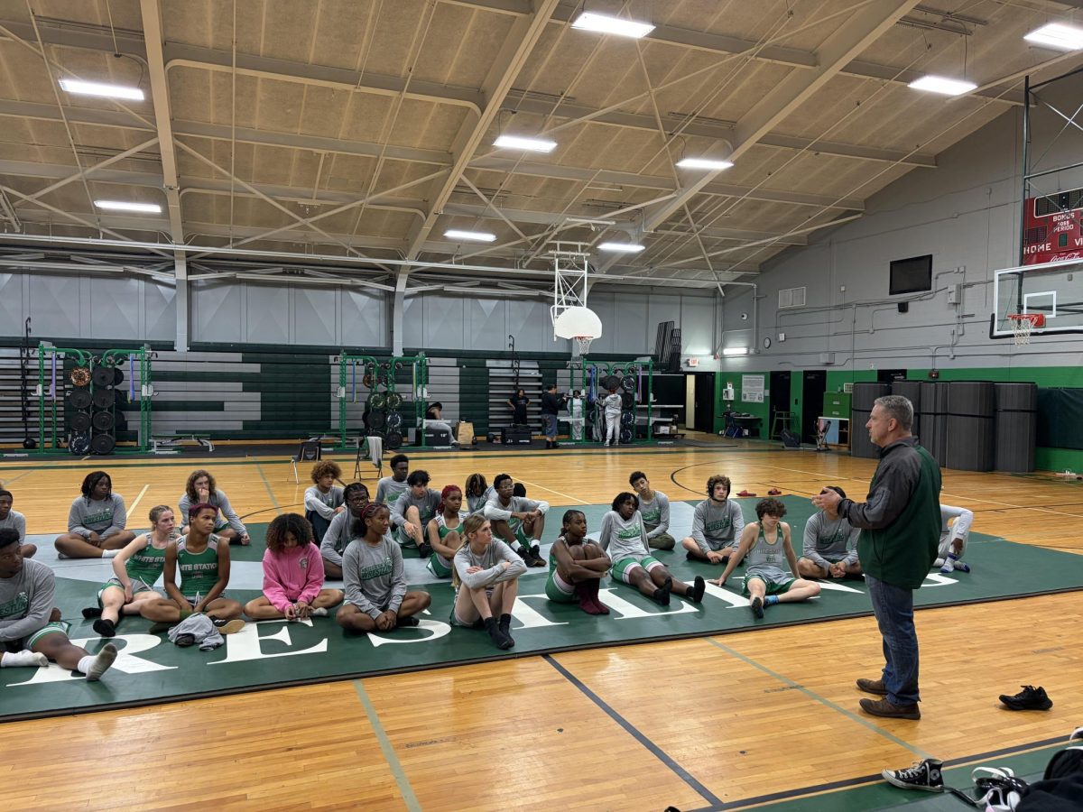  Cailee Williams (10) and the wrestling team listen to Coach Jim Kurtz before heading to a dual. Williams was able to connect quickly with the team after joining this year.