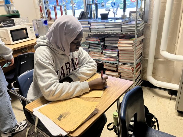 Aishatou Mbow (11) grades papers. Grading is done by many TAs (teacher assistants) as part of their duties.
